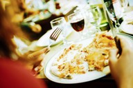 Plate full of rich foods and glass of wine