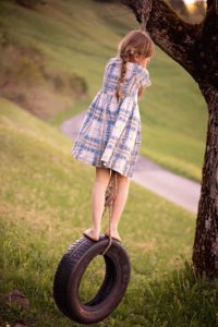 Girl swinging on tire
