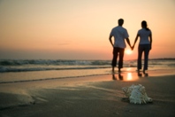 Spouse holding hands on beach