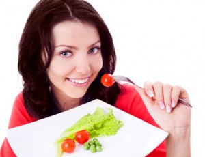 woman eating vegetables and balancing her meal times at college