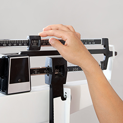 Woman weighing herself on a scale