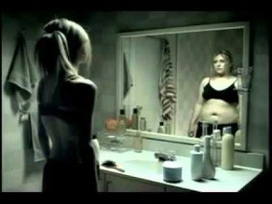 Woman looking at her body in the mirror and dealing with body image concerns