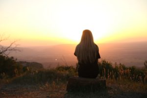 Woman enjoying sunrise and not worried about her natural weight