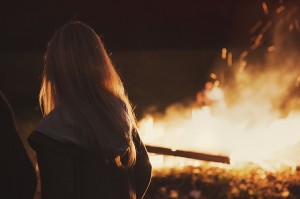 girl looking at a fire thinking about a sexual assault