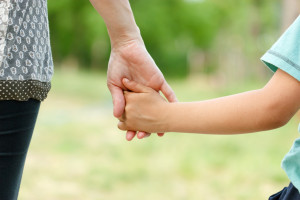 Mother holding a hand of her son