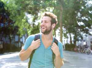 Happy young man traveling with backpack