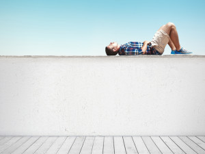 Man lying on a wall