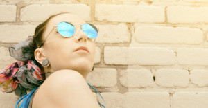 portrait young active girl of the hipster outdoors in sunglasses