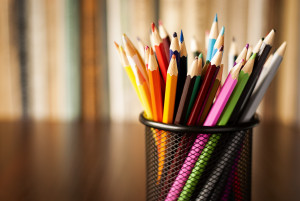 Wire desk tidy full of coloured pencils