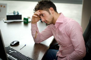 Preoccupied, worried young male college student staring at computer trying to stay healthy in college