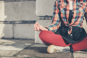 Young woman meditating in the street