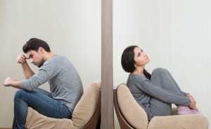 Conflict between man and woman sitting on either side of a wall