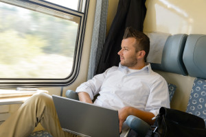 Man looking out the train window laptop