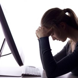Stressed out woman sitting in front of a computer fighting binge eating disorder