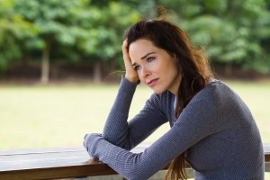 Sad depressed woman sitting outdoors