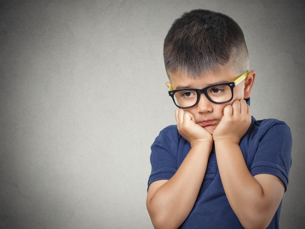 Young boy with head in his hands after hearing about his parents dicorce