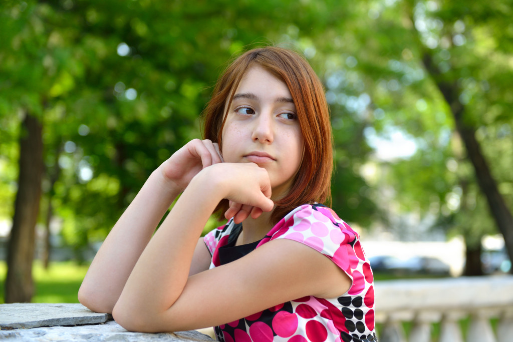 Young girl alone in park, face close up.