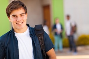 teen boy carrying schoolbag