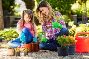 Mother and daughter planting flowers together.