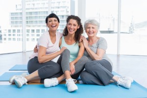 Full length of cheerful women in yoga class