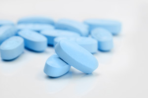 Bunch of blue pills on grey table