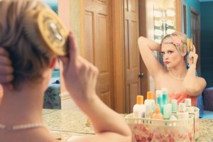 pretty woman looking in mirror while comparing Barbie and Binge Eating Disorder