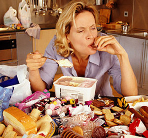 Lady eating and contemplating Binge Eating Disorder vs Basic Overeating