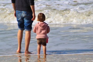 Mother and daughter standing on the shore