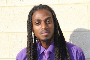 Black man is purple shirt and tie