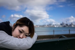 lady with head on rail by river