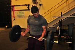 Man lifting weights at gym concerned about Muscle Dysmorphia