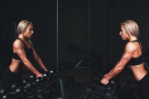 Woman working out in gym battling exercise addiction and Eating Disorders