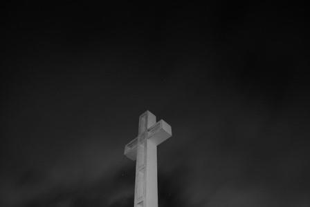 White cross with black night background.