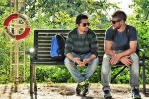 Male friends sitting a bench speaking