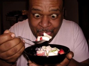 Man excited to be eating dessert in the middle of the night.