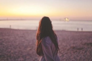 Woman on beach suffering from poor body image