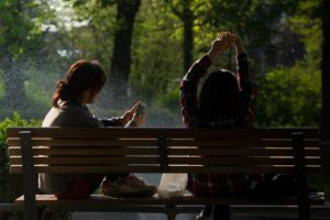 Woman using smartphone while sitting on bench.