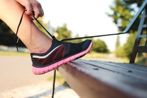 woman lacing a running shoe
