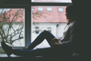 Woman in window thinking about concerns with eating disorder treatment centers