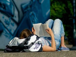 College student reading a book on Poly-substance Abuse