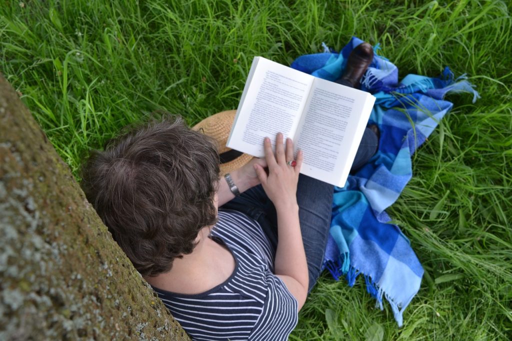 College Student Reading A Book About Clean Eating