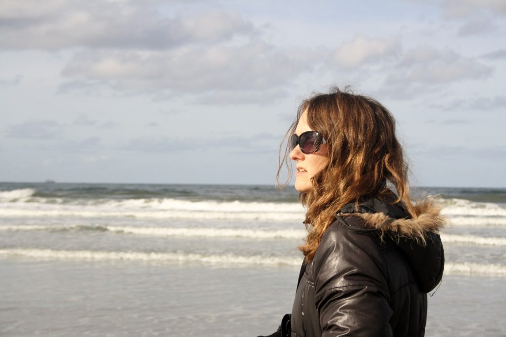 Woman walking on the beach outside her treatment program