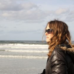 Woman walking on the beach outside her treatment program