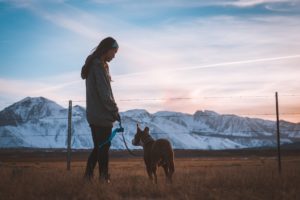 Lady walking a dog near the mountains