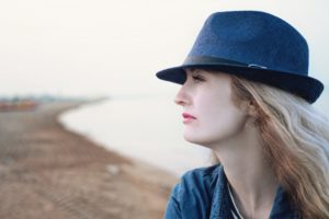 Woman sitting at the beach contemplating her Binge Eating Disorder