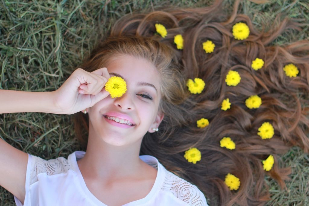 Girl laying grass with flowers