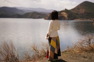 Woman at lake thinking about positive Affirmations