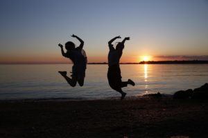 Girls jumping on beach, celebrating scholarship