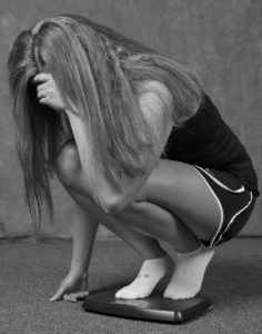 Woman checking her weight on the scales