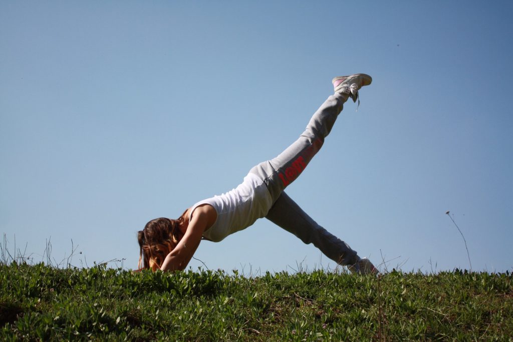 Woman doing yoga in the grass